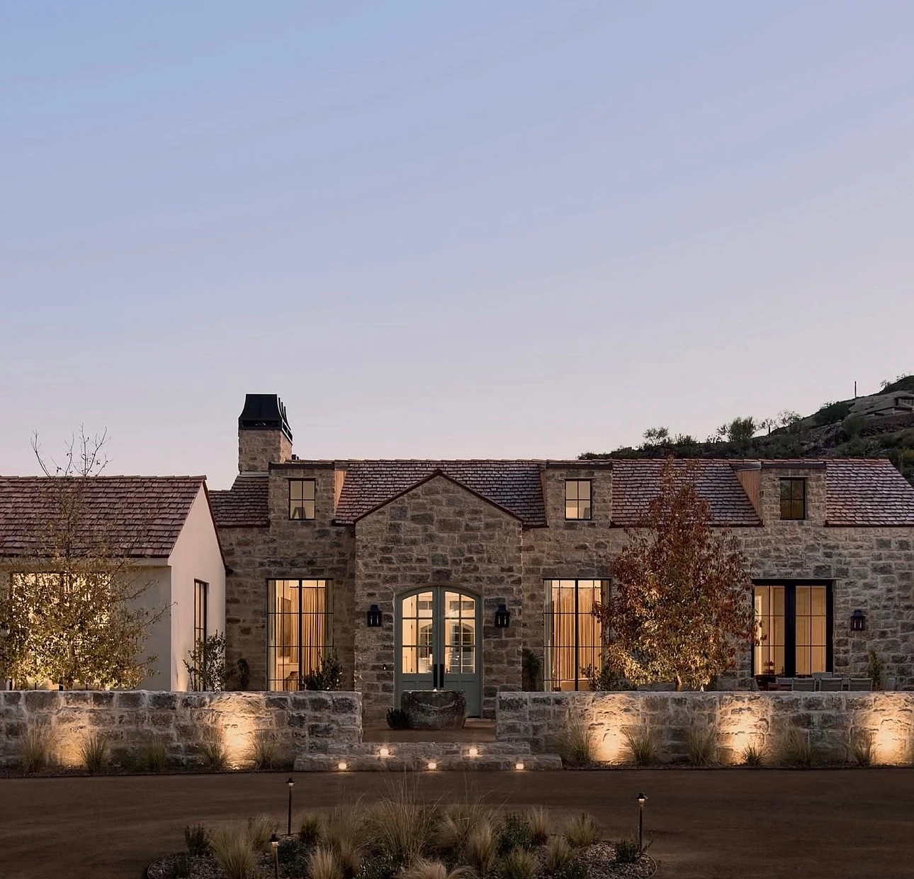 Stone estate with landscape lighting at dusk